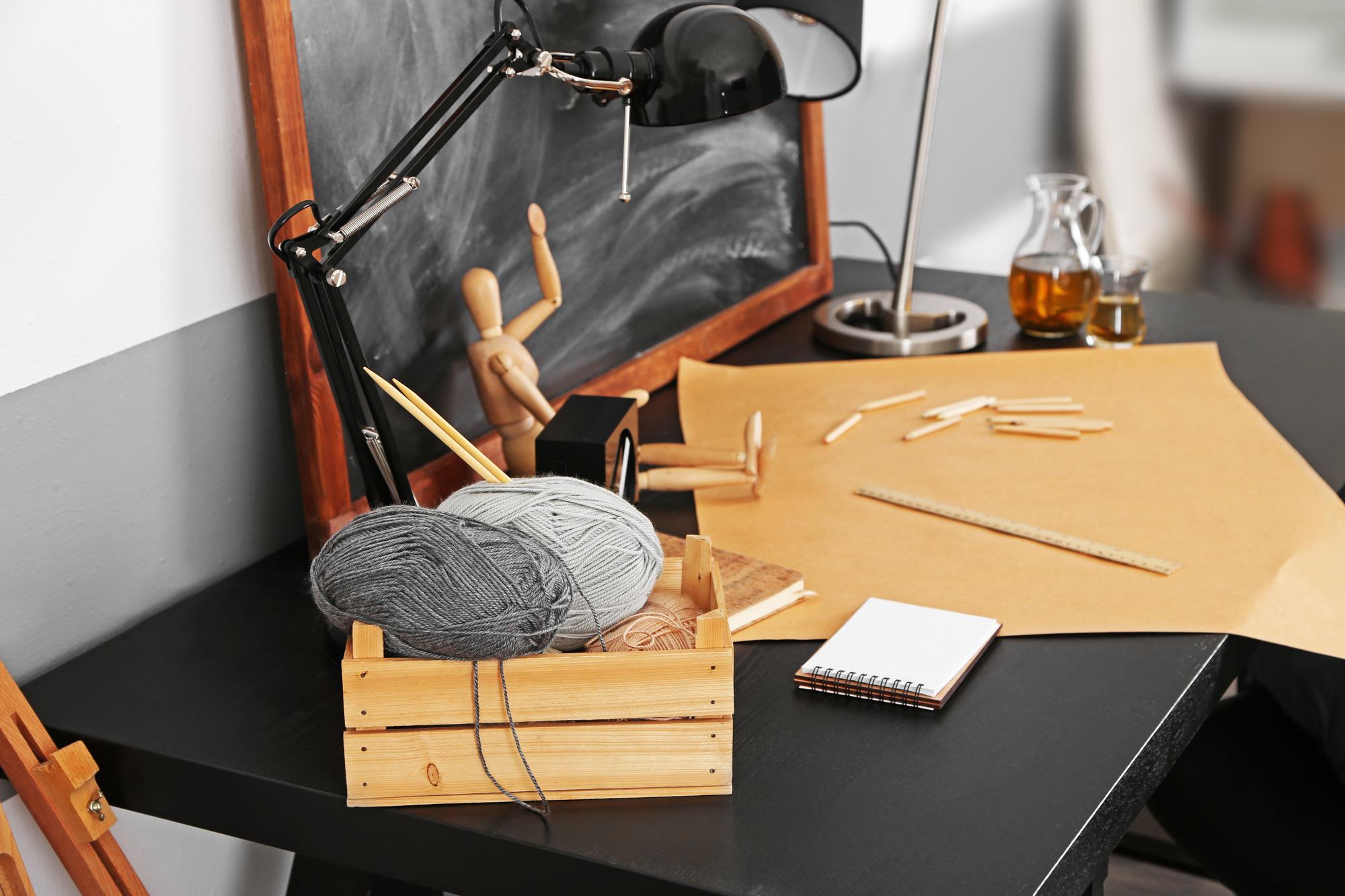 Workshop table with threads, needles and pattern sketches